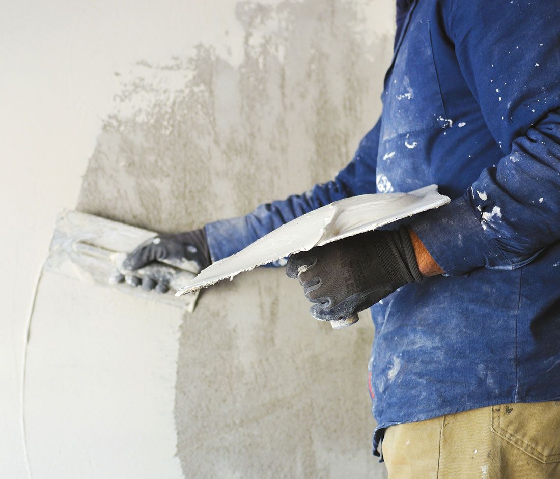 A plasterer, plastering a wall